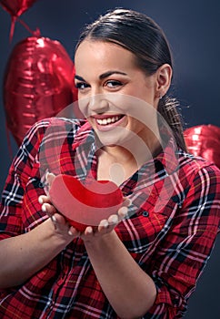 and smiling woman holding red heart