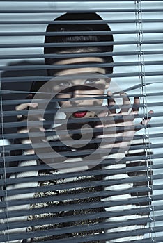 spy woman behind shutters photo