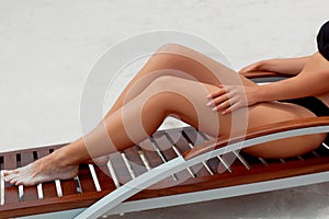 Sexy Suntan Bikin Woman Legs Relaxing Lying Down near Beach In Resort Spa Hotel On Travel Holidays Vacation. Beauty Skincare. Prot