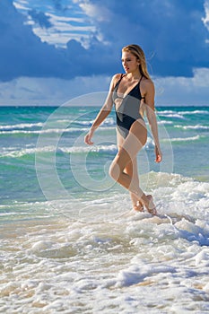Sexy tanned girl in bikini swimsuit on sea background. Fashion woman in bikini relax on beach. Happy summer lifestyle