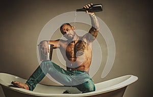 Sexy undress man sit on bathtub in bathroom, men holiday with champagne. Celebrating christmas or birthday. Private sex