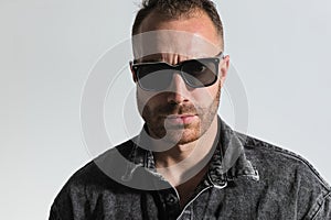 Sexy unshaved guy wearing sunglasses and posing