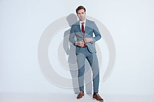 Sexy unshaved man unbuttoning elegant blue suit