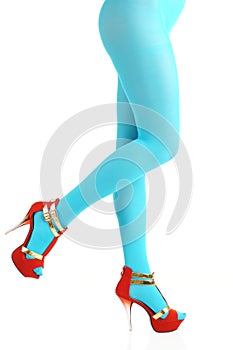 Sexy view of slim woman body lower part wearing light blue tights and high-heeled shoes