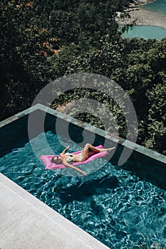 Sexy woman in bikini enjoying summer sun in swimming pool