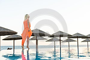 Sexy woman in bikini is posing in the swimming pool. Wellness and spa luxury resort.