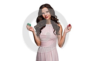 woman in a chic gently pink dress holding colored poker chips. Woman winning