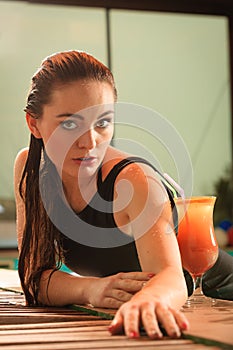 woman with cocktail drink at poolside