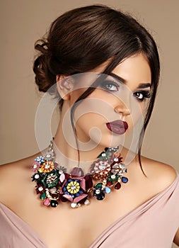 woman with dark hair and bright makeup, with necklace