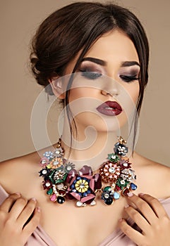 woman with dark hair and bright makeup, with necklace