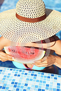 woman with dark hair eating watermelon