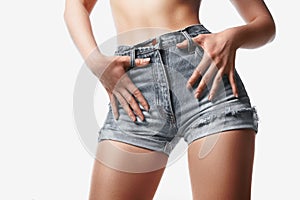 Sexy woman in fashion grey jeans shorts on white background. Perfect hot booty and erotic curves hips. Summer Style