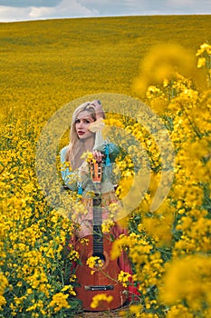 sexy woman in the field with a guitar. concept freedom, inspiration, relaxation.