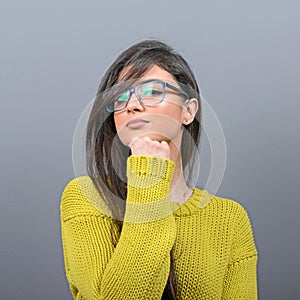 Sexy woman with glasses posing against gray background