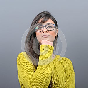 Sexy woman with glasses posing against gray background