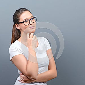 Sexy woman with glasses posing against gray background