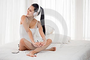 Sexy woman listening to musics in bedroom photo