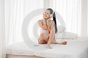 Sexy woman listening to musics in bedroom photo