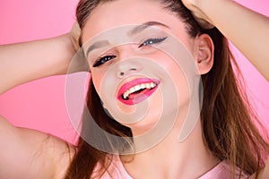woman with long hair on pink background. Makeup for sensual model with soft skin. Beauty and hairdresser salon