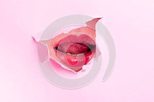 woman mouth with lipstick thru pink ripped board