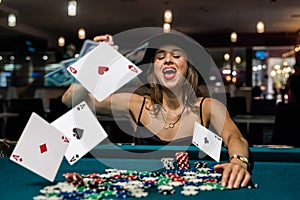Sexy woman playing poker in elegant black dress at clubhouse.