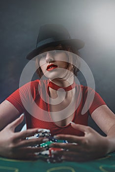 sexy woman with poker cards and chips at poker table in casino. the most gambling game