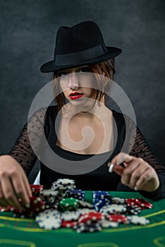 sexy woman with poker cards and chips at poker table in casino. the most gambling game