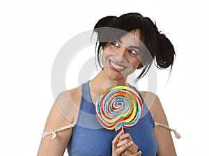 woman with ponytails biting her lips holding and licking sweet caramel big lollipop photo