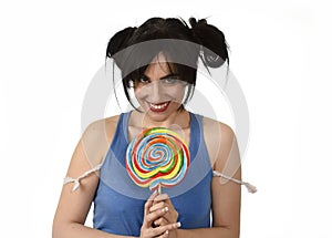 woman with ponytails biting her lips holding and licking sweet caramel big lollipop photo