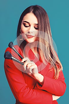 Sexy woman with professional makeup brush tool. Fashion portrait of woman. jewelry earrings. Girl in red jacket. beauty