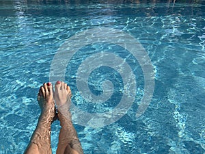 Sexy Woman`s feet in the swimming pool