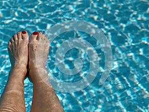 Sexy Woman`s feet in the swimming pool