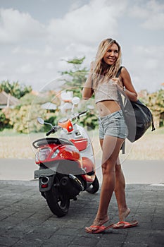 woman standing near the motobike. Lifestyle portrait bright toned colors,cool rock n roll girl,Enjoy ride in summer photo