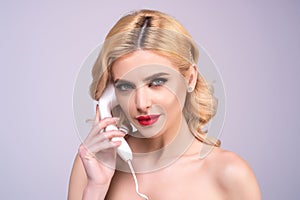 Sexy woman talking on retro line phone. Portrait of woman holding vintage telephone. Pinup girl with phone handset