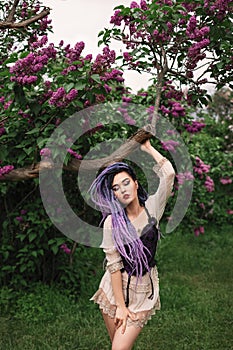 Sexy woman under the lilac tree