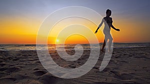 woman walk and run on sand beach the sea coast with sunset behind