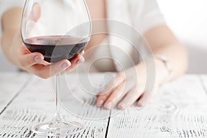 woman in white holding wine glass