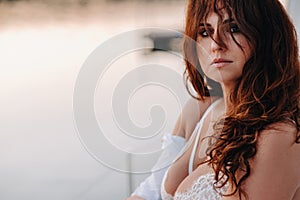 sexy woman in a white shirt enjoys the sunset on her private white yacht