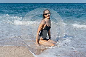 Sexy young brunette posing on her knees in the sea