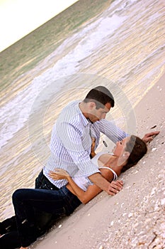 young couple laying together on the beach