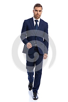 sexy young guy in navy blue suit walking on white background