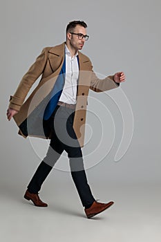 Sexy young smartcasual guy wearing glasses and long coat