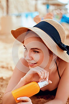 Sexy Young Woman in Bikini  Holding  Bottles of Sunscreen in Her Hands. Skincare. A Female  Applying Sun Cream Creme