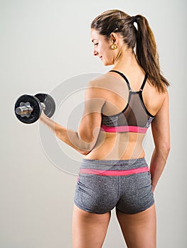 young woman doing dumbbell curl