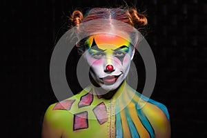 Sexy young woman with a face painting clown