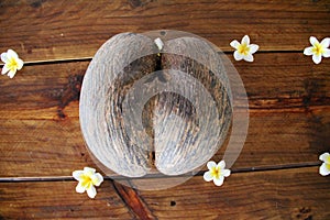 Seychelles double with flowers decorated on an old wooden table