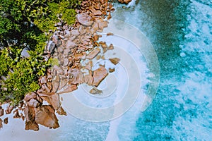 Seychelles La Digue Island. Aerial top view of ocean waves hitting huge bizarre granite rocks on the tropical beach anse