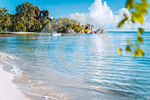 Seychelles. La Digue island famous Anse Source d`Argent beach. Pleasure tourist vacation boat in ocean shallow lagoon