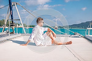 Seychelles, young men on vacation with sailing boat at the Seychelles tropical island