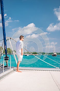 Seychelles, young men on vacation with sailing boat at the Seychelles tropical island